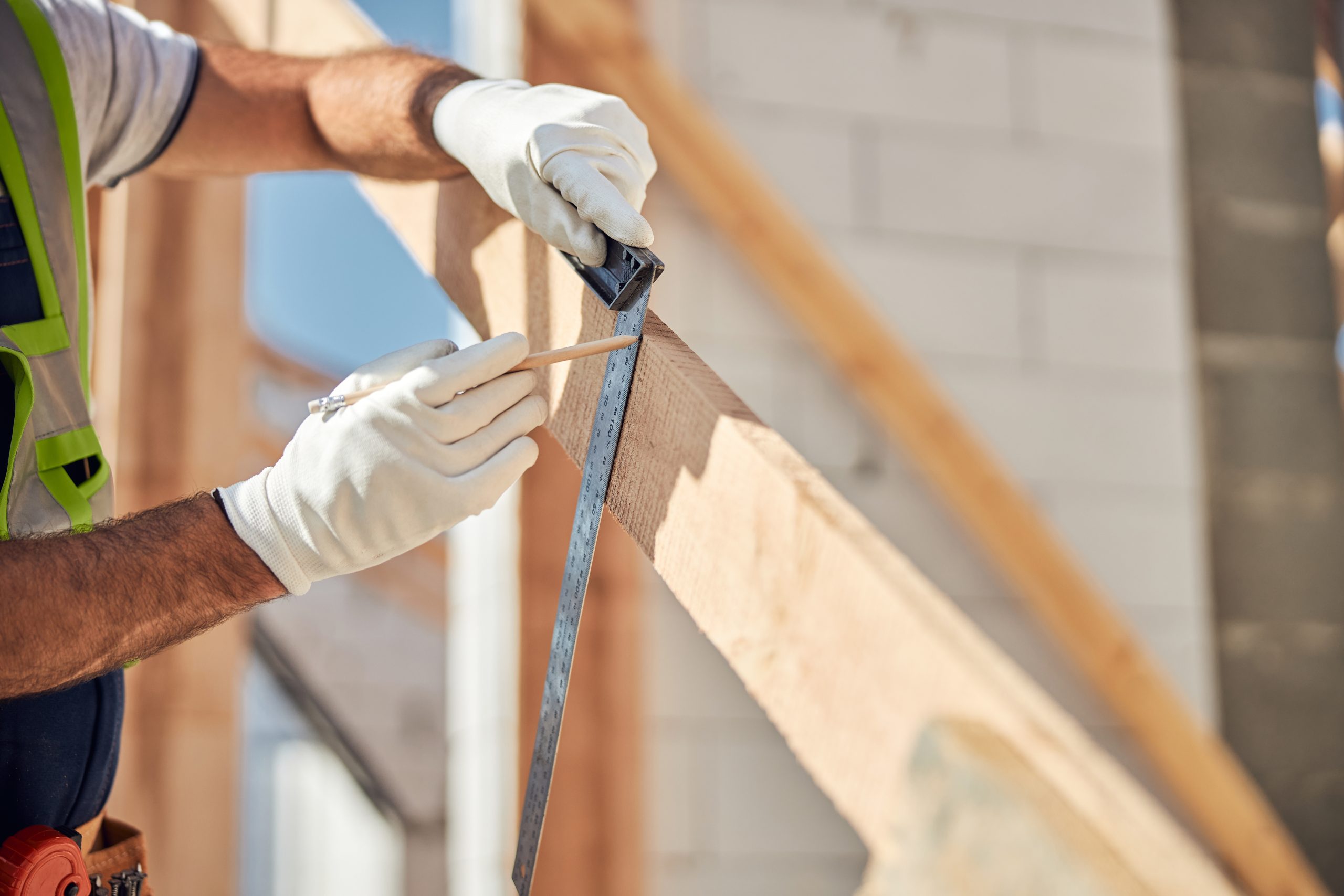 Competent builder making mark on the beam before droving nail