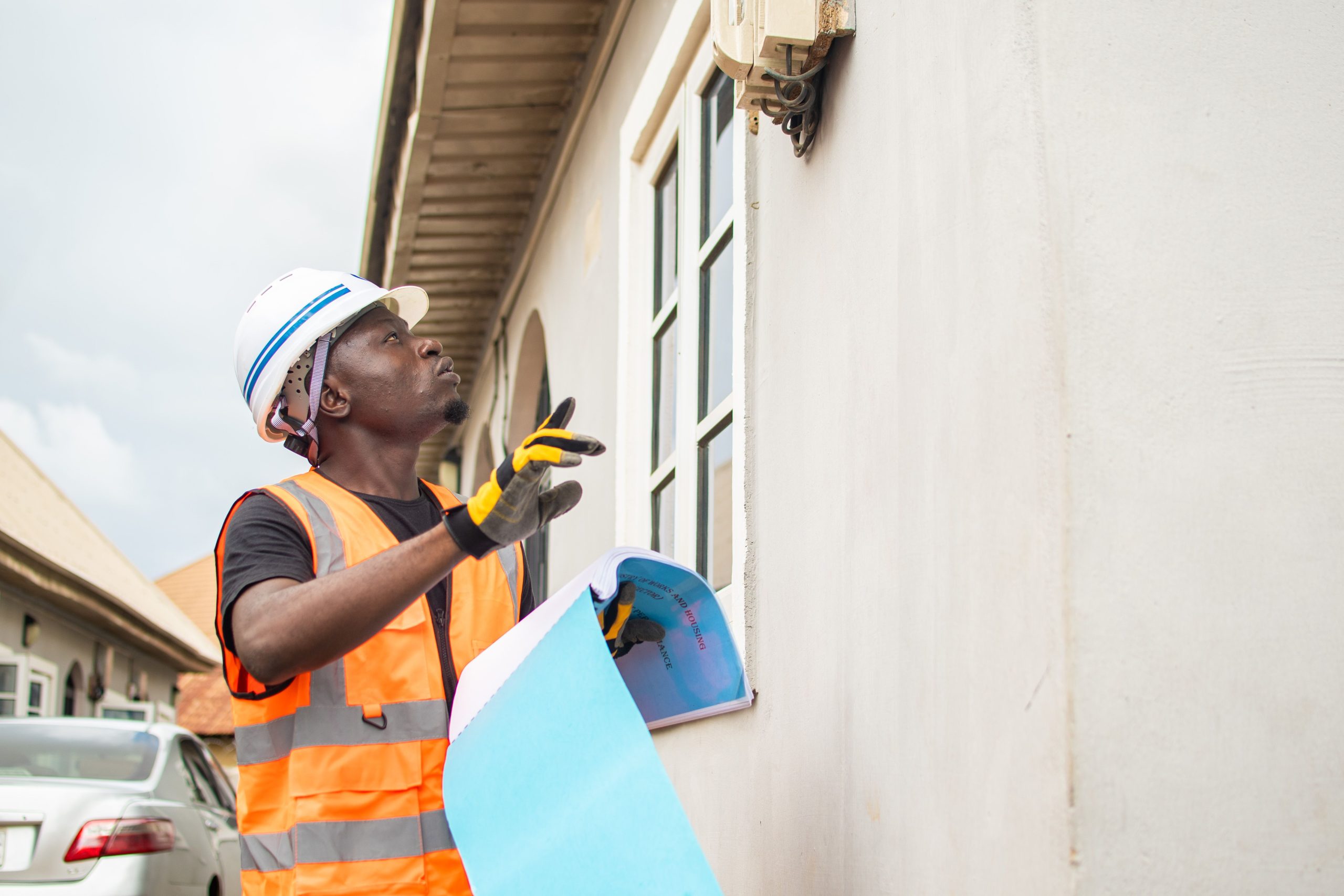 A person wearing an orange safety vest is engaging in home repair work